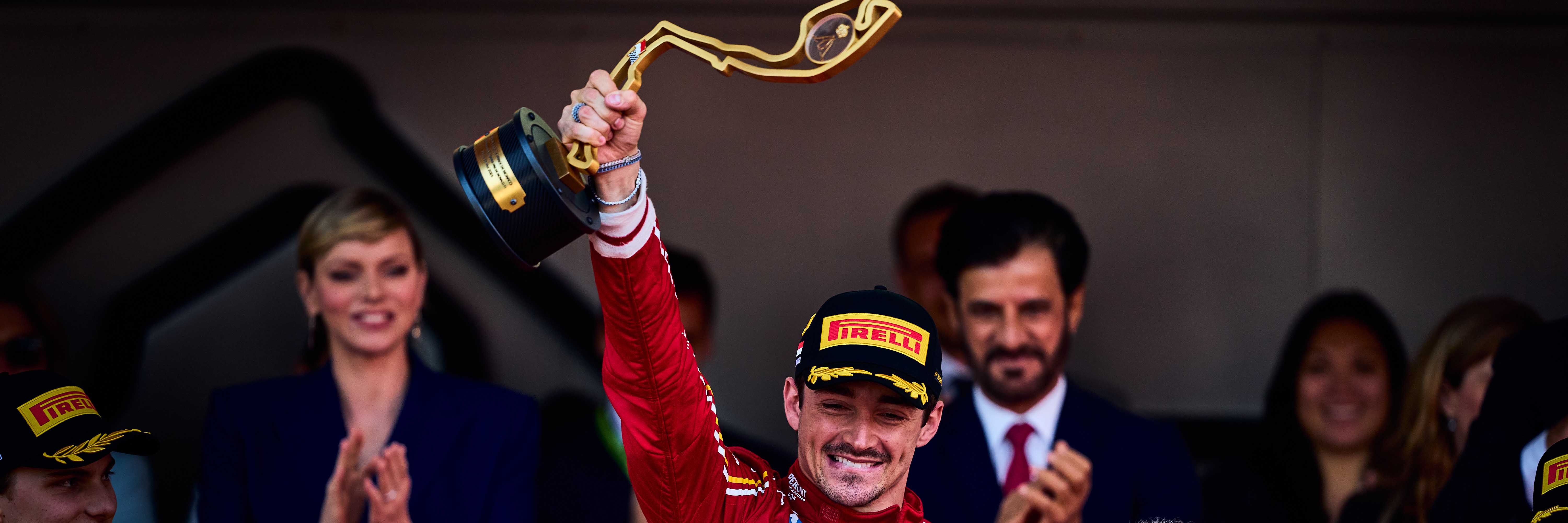 Charles Leclerc lifting the 2024 Monaco Grand Prix trophy on the podium