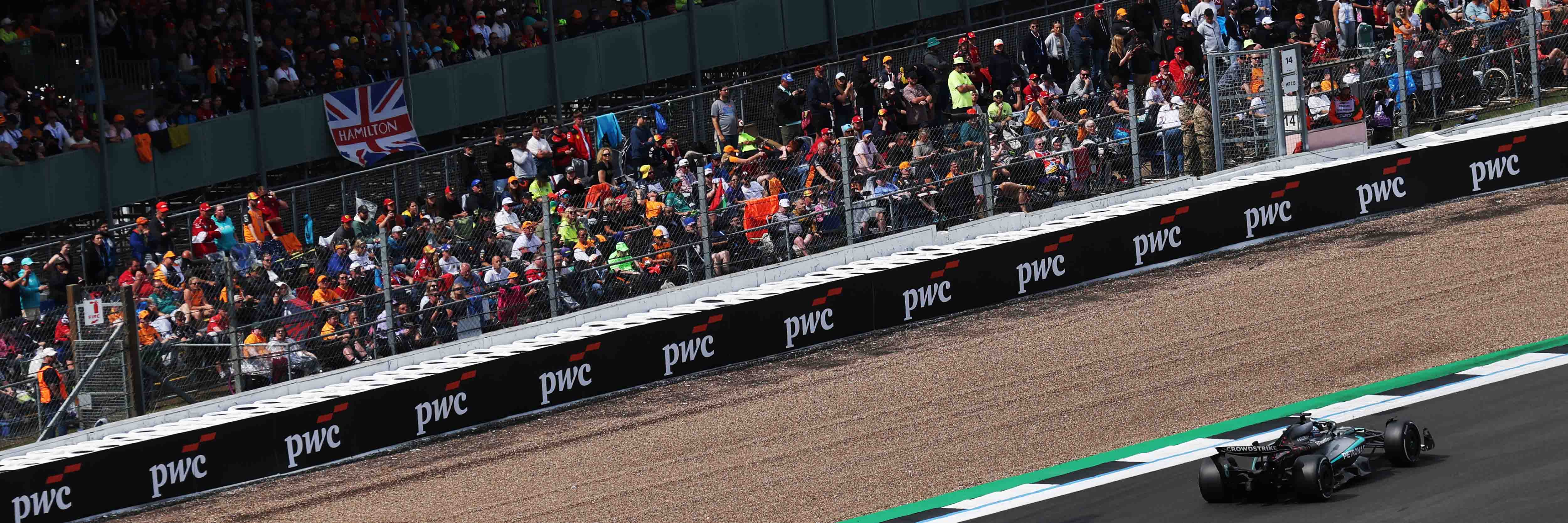 Luffield spectators at the British Grand Prix with a Mercedes car on track
