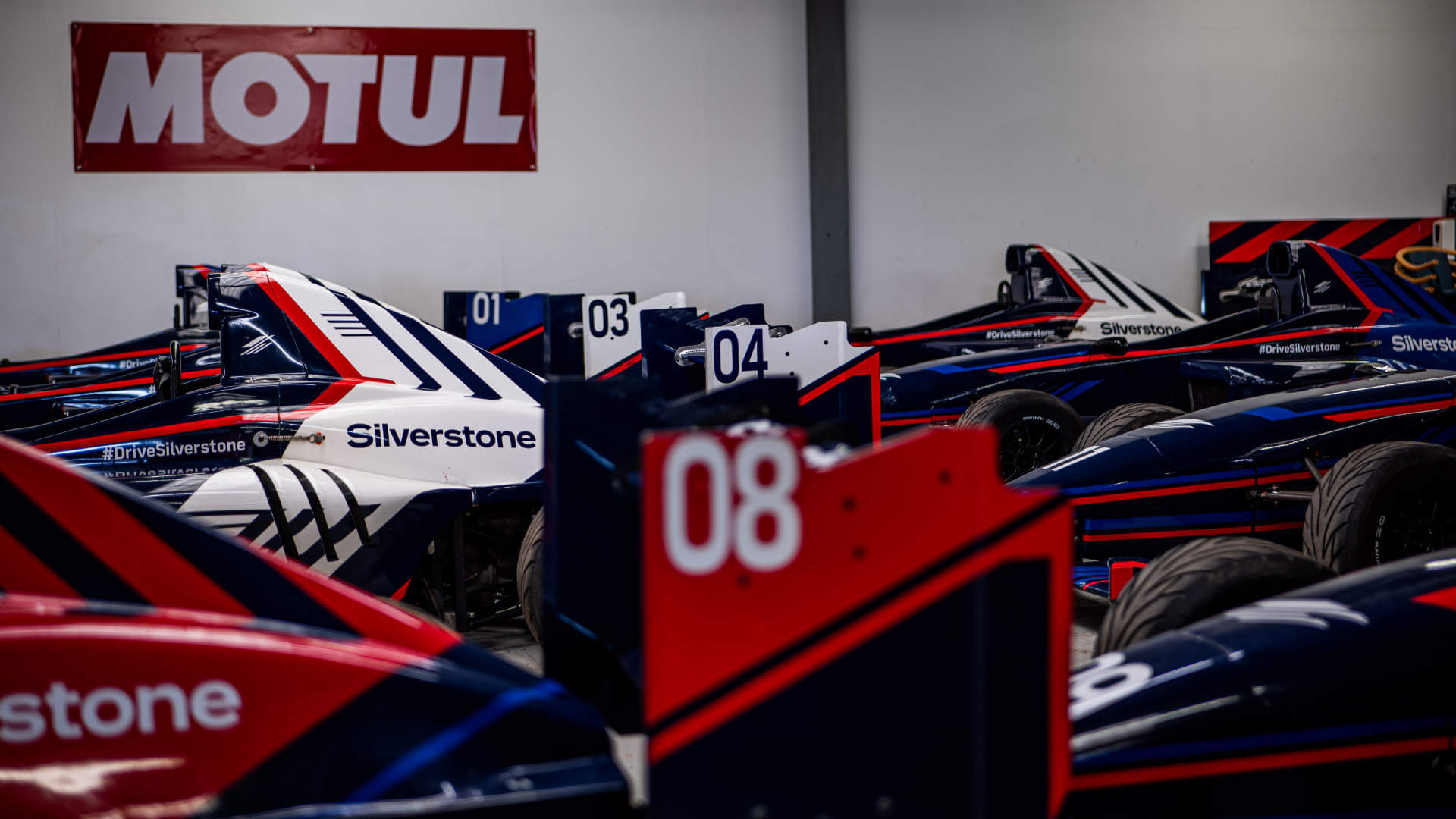 Single seaters in a garage, next to each other 