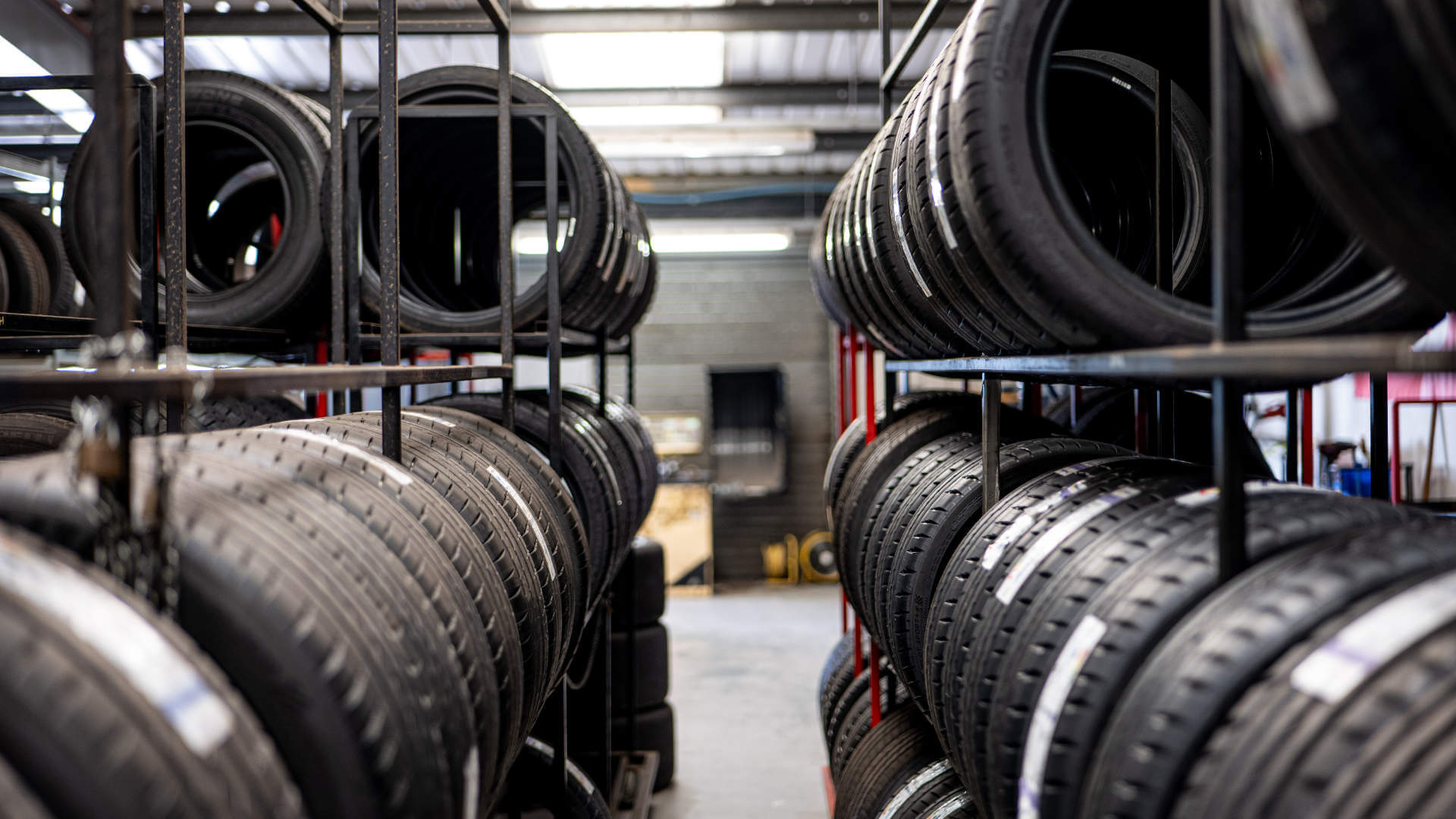 Car tyres sit stacked on shelves