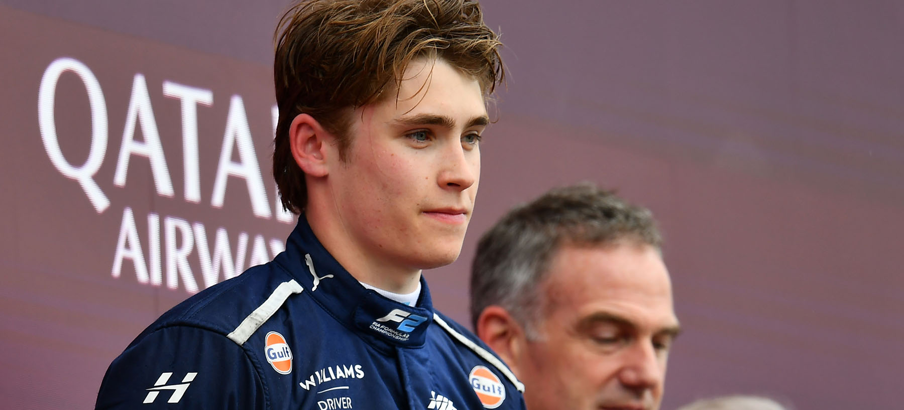 Luke Browning, close-up shot on the podium at the British Grand prix. Looking to the right, camera is side-on, front