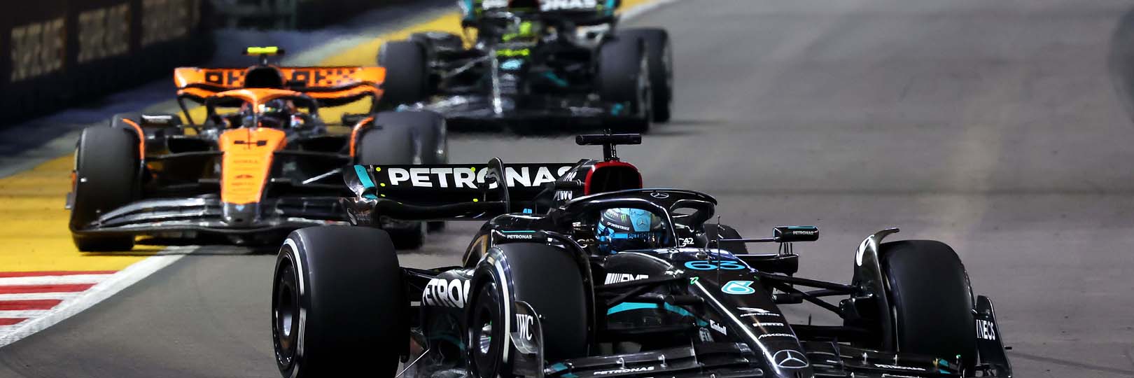 George Russell, Lando Norris and Lewis Hamilton on track at the Singapore Grand Prix