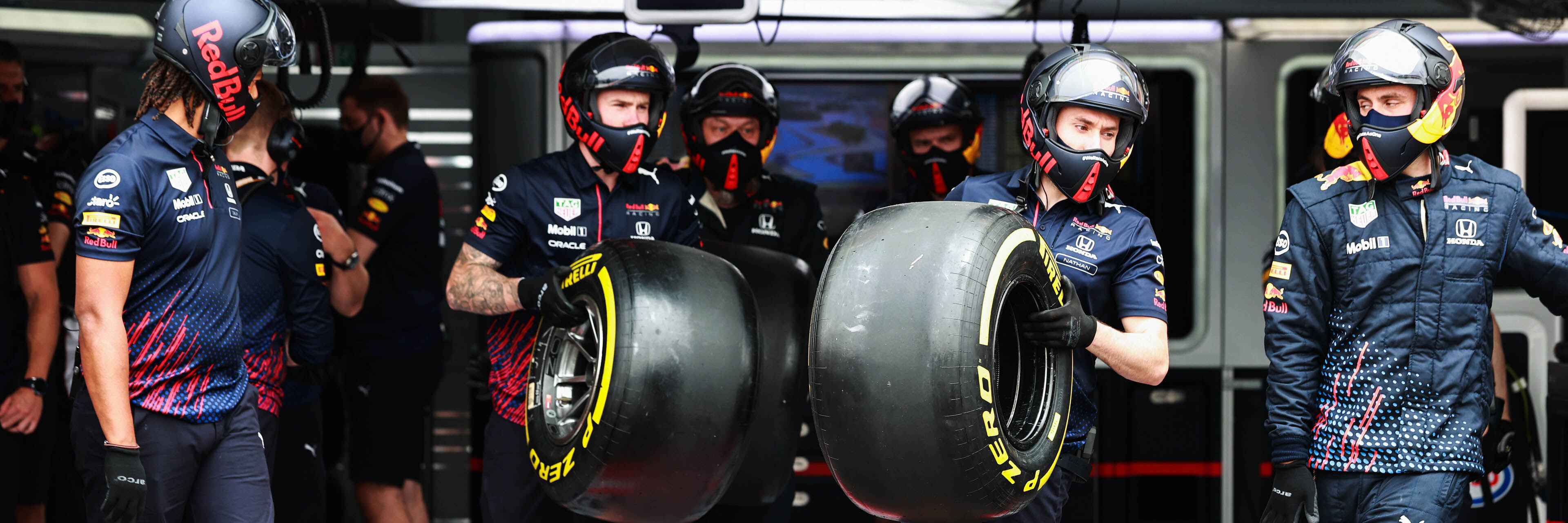 Red Bull mechanics in the F1 garage ready for a pit stop with Pirelli tyres