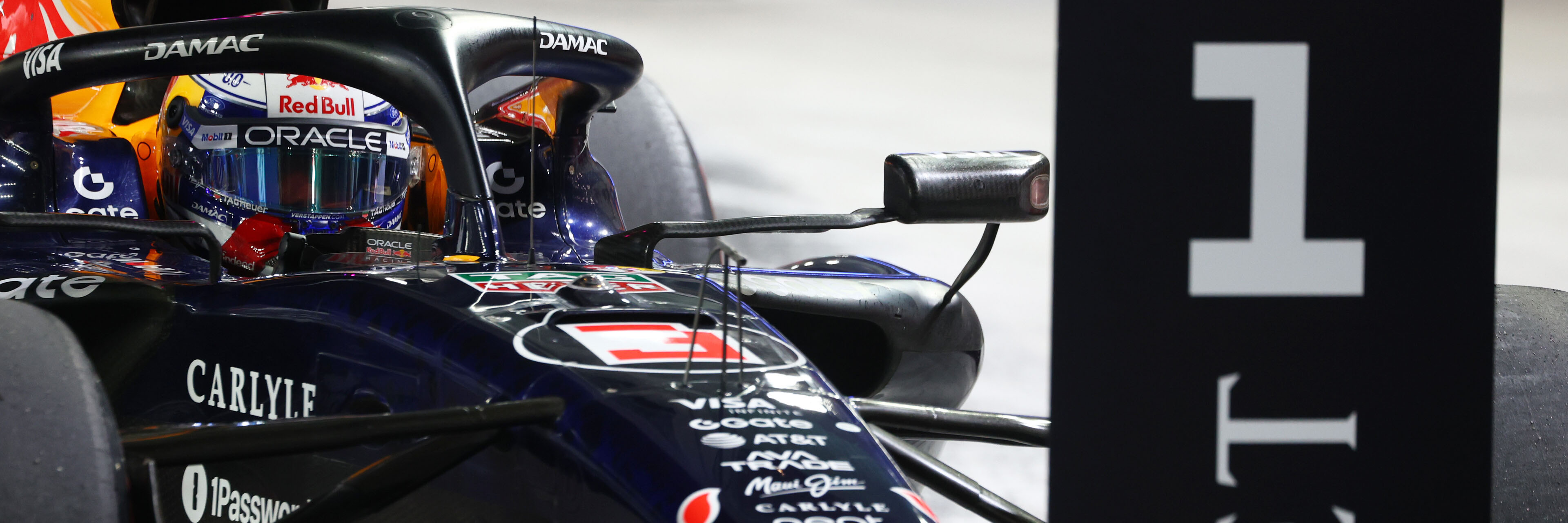 Max Verstappen in his Red Bull Racing F1 car pulls up to the number 1 board in parc ferme of the 2026 Singapore Grand Prix
