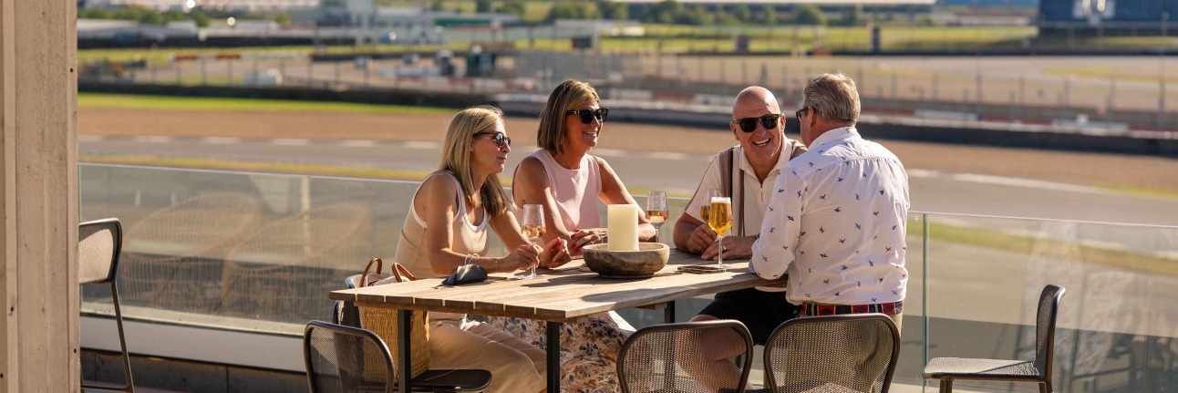 A group of people enjoying the Escapade Silverstone decking at a Summer Sundowners event