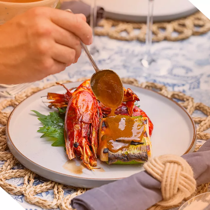 nova glamping food. a hand serving a dish with sauce