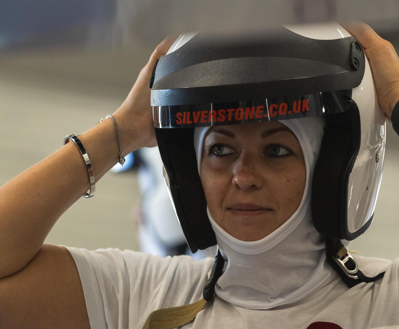 A lady puts on her helmet