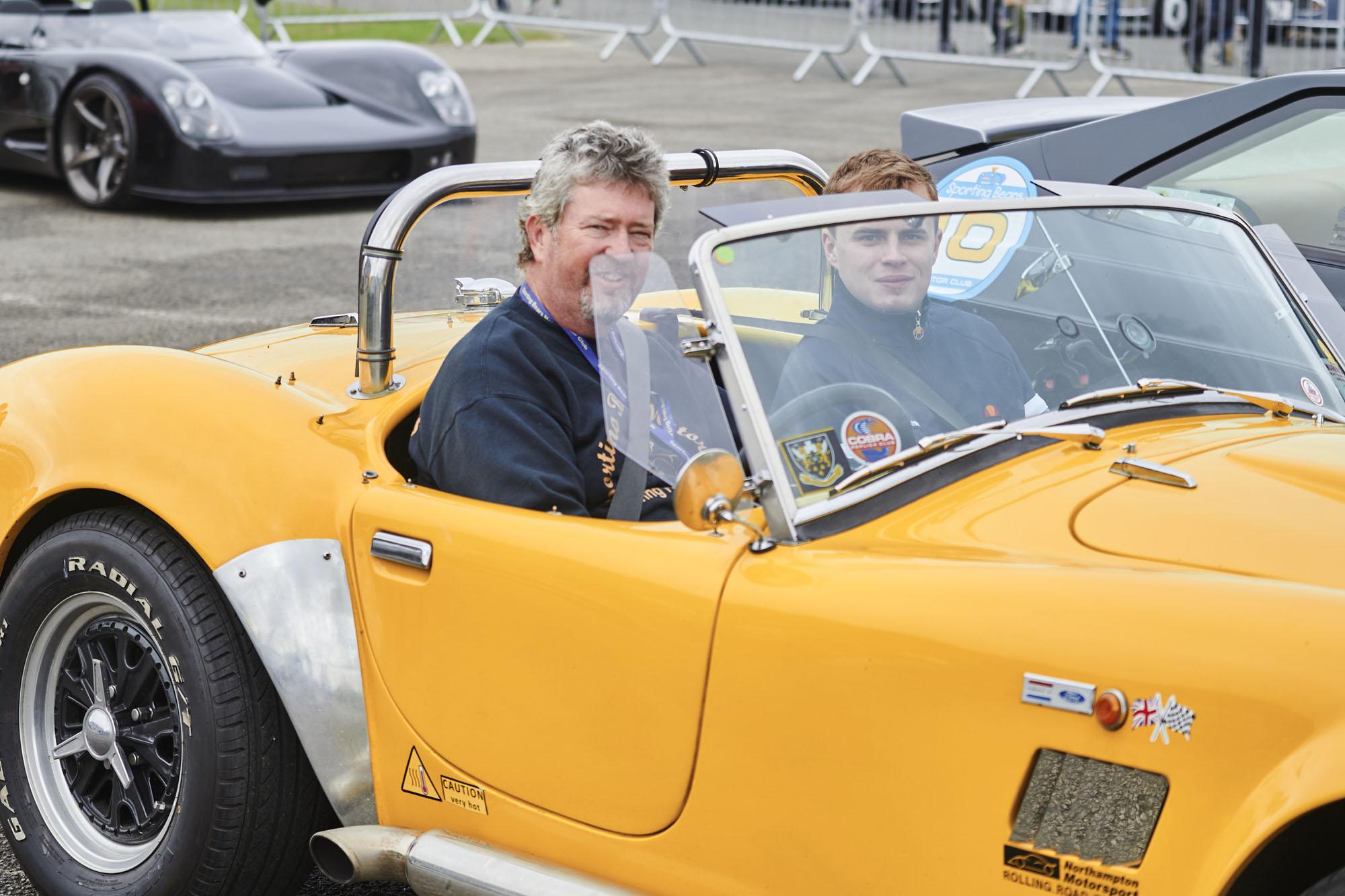 two guys driving a classic car 