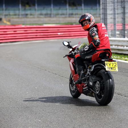 Rider looks over shoulder at bike track day at Silverstone