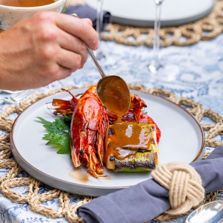 food served with person pouring sauce over seafood