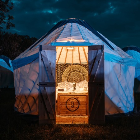 glamping tent in the dark with lights inside. door open